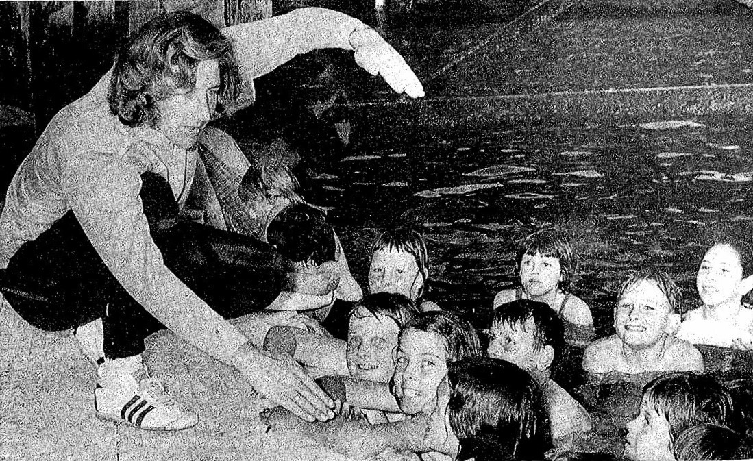 Black and White photo with Dawn Fraser demonstrating, to a group of 9 year old how the swim in the Balmain pool